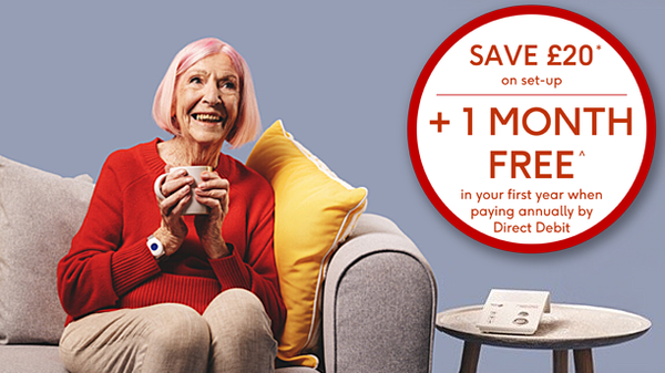 older woman smiling with a personal alarm