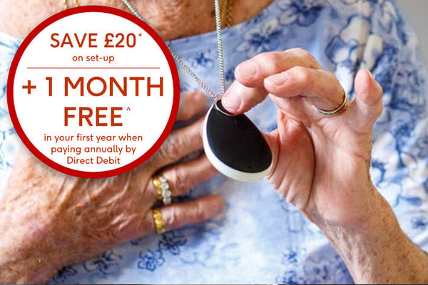 Older person holding black GO pendant