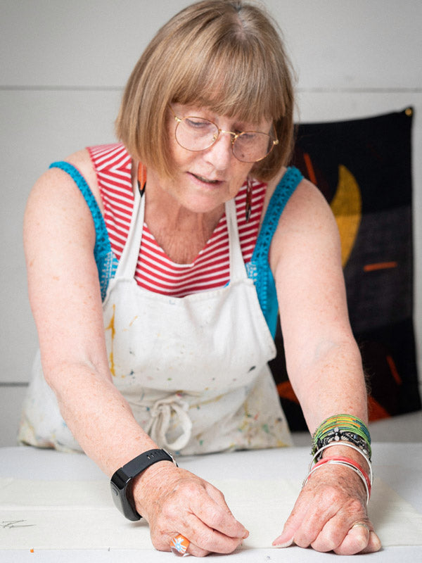 Woman wearing a personal alarm watch, working at a table.