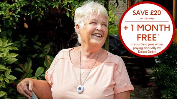 An older woman with short white hair smiling outdoors wearing a Digital Fall Alarm pendant
