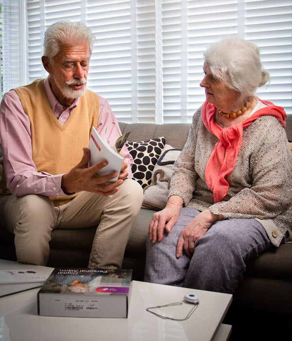 Elderly couple reading the fall alarm user guide